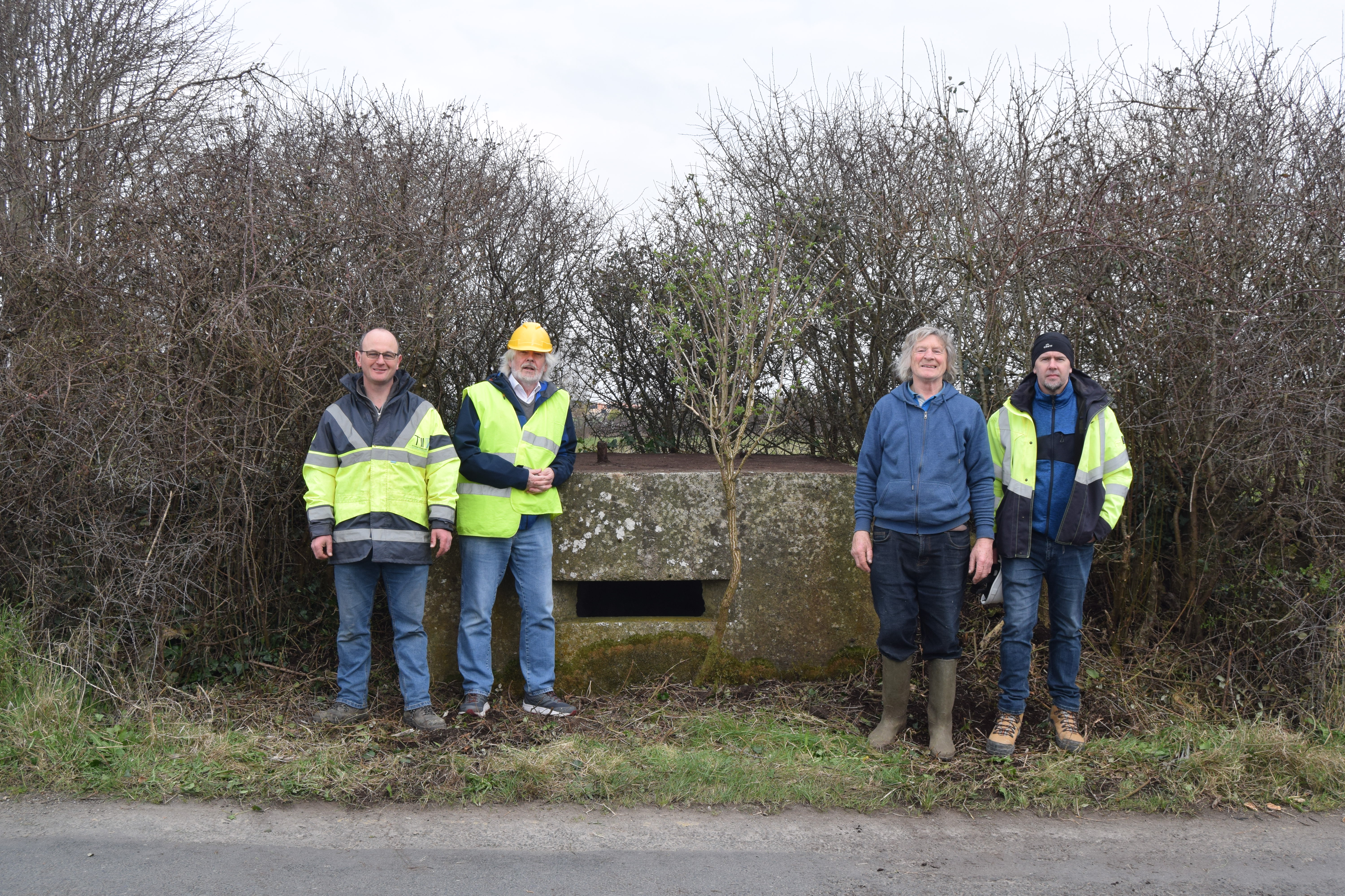 Illustration 12: Paul O’Keeffe (TII Project Archaeologist), Tom Cassidy (Buildings Archaeologist, Fola Heritage Services), Liam Dillon (landowner) and Ed Lyne (LCCC Resident Archaeologist) at a roadside pillbox (PB21) in Coolrahnee (Photo: TII)